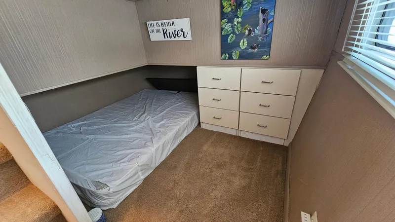 Slide: The Image of Cozy bedroom in 1993 Skipperliner 47 SL with bed, drawers, and river-themed decor. - 29