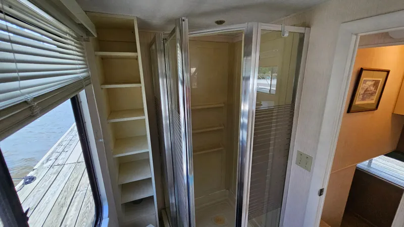 Slide: The Image of Interior of 1993 Skipperliner 47 SL with shower, shelves, and window view. - 31