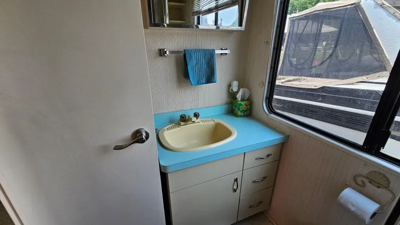 Slide: The Image of Bathroom interior of 1993 Skipperliner 47 SL with blue countertop and window view. - 32
