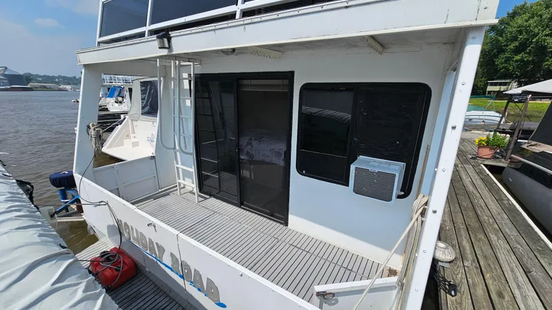 Slide: The Image of 1993 Skipperliner 47 SL houseboat docked, featuring a spacious deck and sliding glass doors. - 5