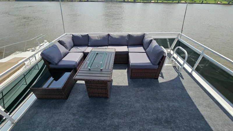 Slide: The Image of Outdoor seating area on 1993 Skipperliner 47 SL boat, featuring wicker furniture and river view. - 8