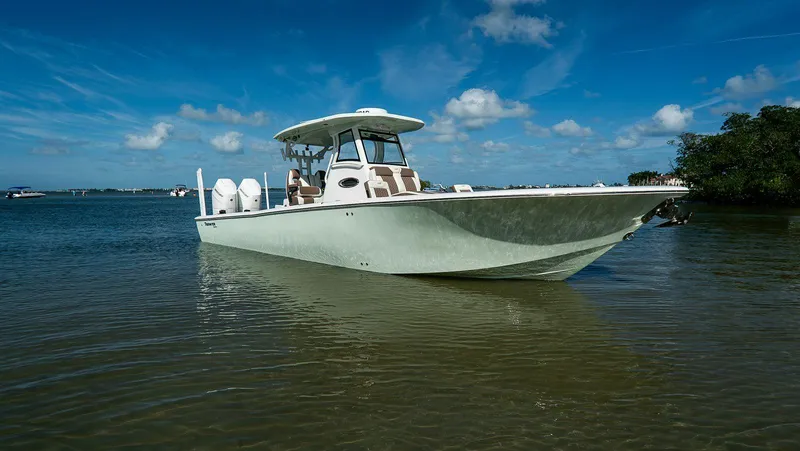 Slide: The Image of 2026 Tidewater 3100 Carolina Bay boat on calm water under blue sky. - 2