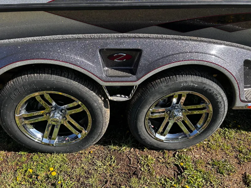 Slide: The Image of 2023 Ranger Z521R trailer with chrome wheels and Kenda tires on grass. - 13