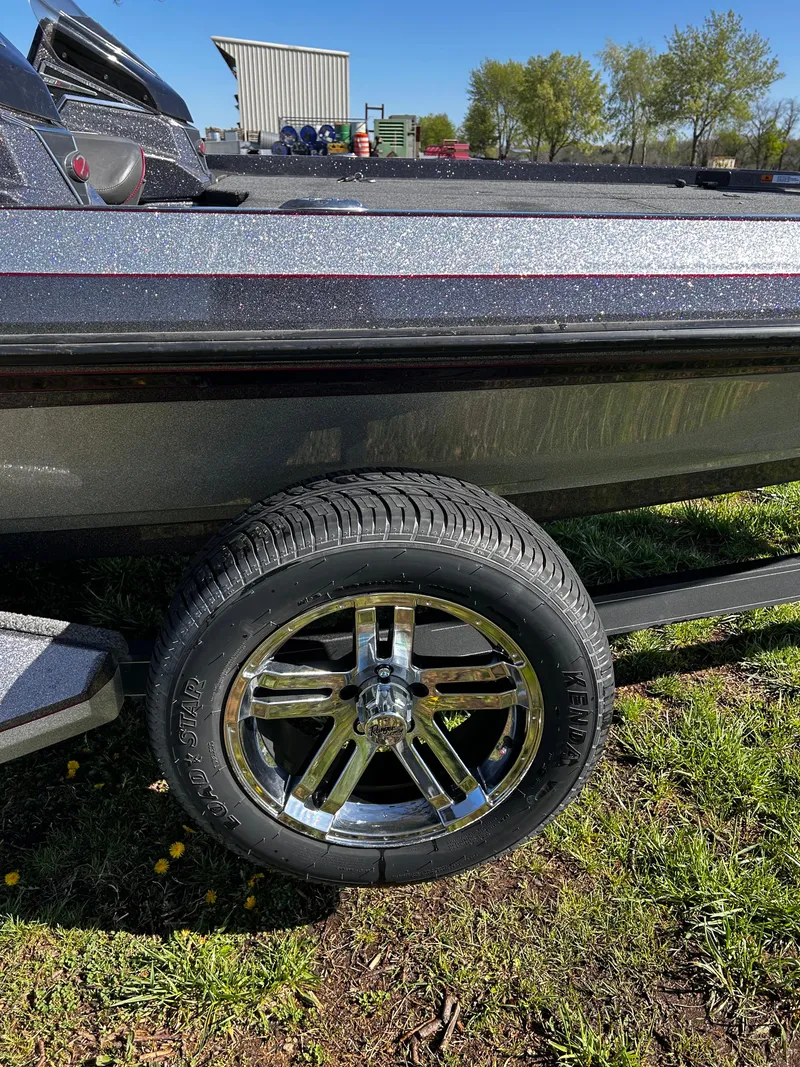 Slide: The Image of 2023 Ranger Z521R boat trailer with chrome wheel on grass. - 14