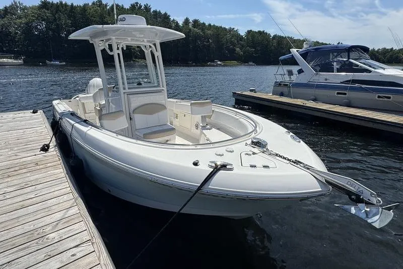 Slide: The Image of 2021 Robalo R242 Center Console boat docked on a sunny day. - 2