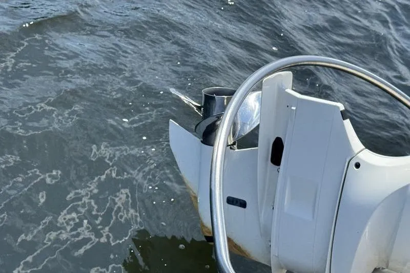 Slide: The Image of 2021 Robalo R242 Center Console steering wheel and throttle on water. - 3