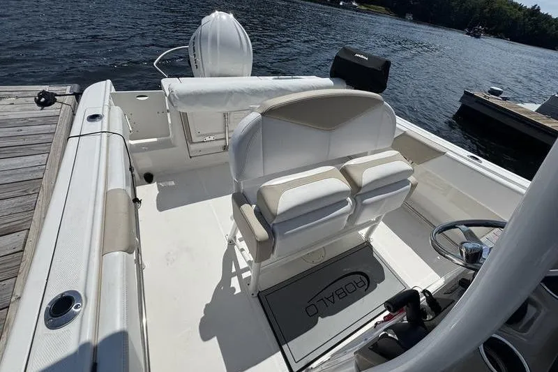 Slide: The Image of 2021 Robalo R242 Center Console boat interior at dock, featuring helm and seating. - 5