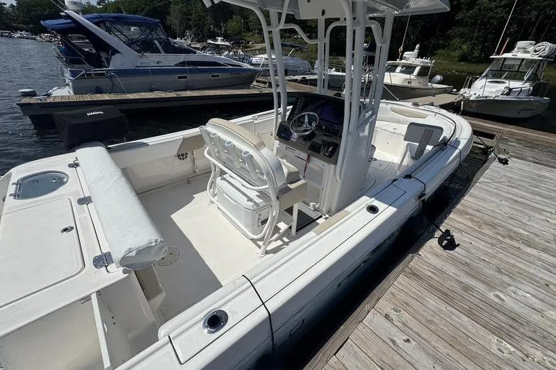 Slide: The Image of 2021 Robalo R242 Center Console boat docked at marina, featuring spacious deck and helm. - 7