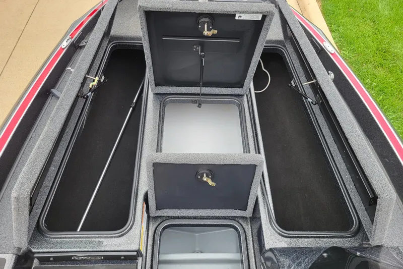 Slide: The Image of 2023 Triton 179 TrX boat storage compartments, open and spacious, with gray interior. - 5
