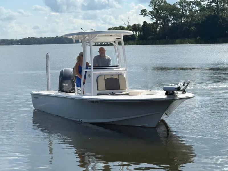 Slide: The Image of 2021 Tidewater 2410 Bay Max boat cruising on a calm lake with two passengers. - 11