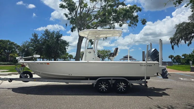 Slide: The Image of 2021 Tidewater 2410 Bay Max boat on trailer, parked outdoors under a sunny sky. - 12