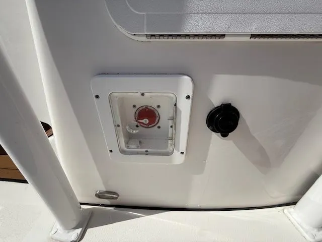 Slide: The Image of 2021 Tidewater 2410 Bay Max boat control panel with red switch and black knob. - 24