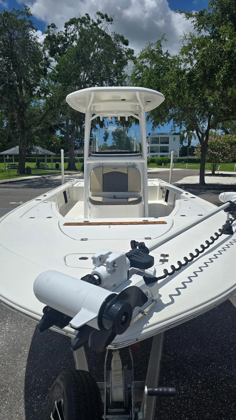 Slide: The Image of 2021 Tidewater 2410 Bay Max boat with trolling motor, parked outdoors under clear sky. - 29