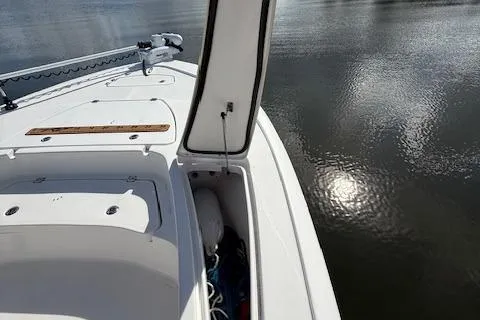 Slide: The Image of 2021 Tidewater 2410 Bay Max boat on calm water, open storage compartment visible. - 37