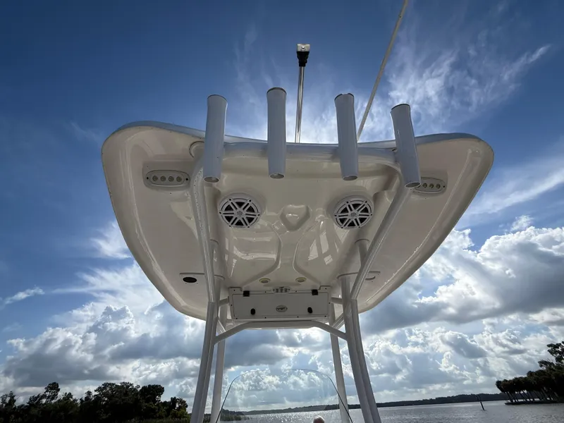 Slide: The Image of Tidewater 2410 Bay Max 2021 boat with T-top and rod holders against a cloudy sky. - 51