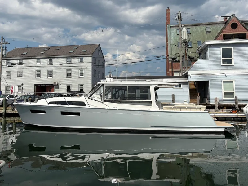 Slide: The Image of 2026 MJM 47R yacht docked by historic buildings under a cloudy sky. - 0
