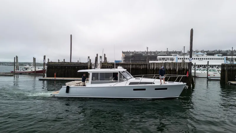 Slide: The Image of 2026 MJM 47R yacht cruising near a marina under overcast skies. - 1