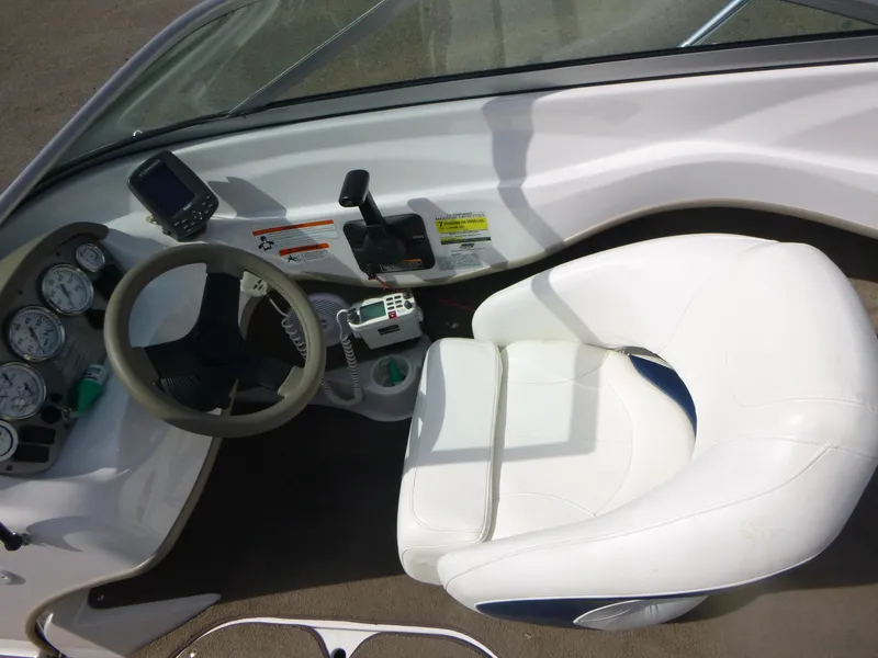 Slide: The Image of 2007 Four Winns 180 Horizon boat cockpit with steering wheel, gauges, and white captain's chair. - 7