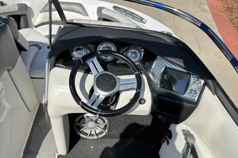 Slide: The Image of 2014 Tigé RZR boat dashboard with steering wheel, gauges, and control panel. - 7