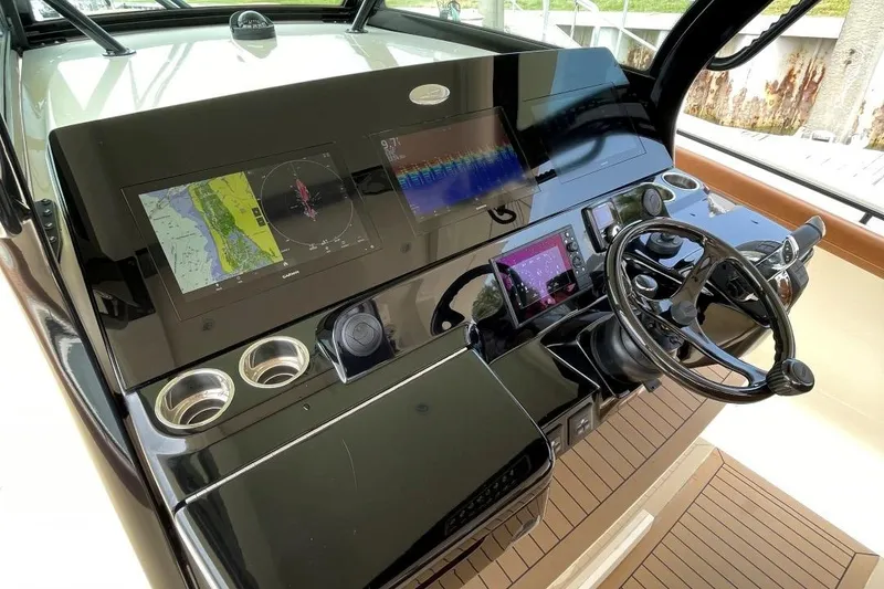 Slide: The Image of 2020 Scout 420 LXF boat dashboard with navigation screens and steering wheel. - 26