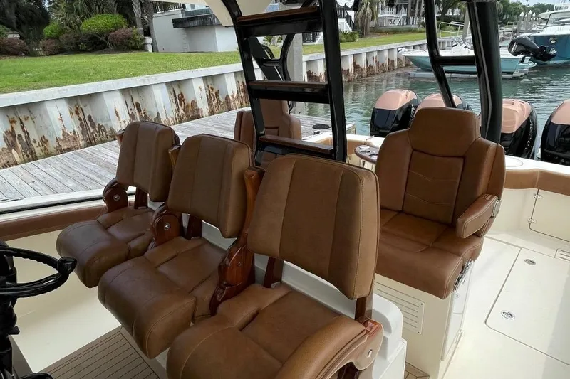 Slide: The Image of Luxury seating on 2020 Scout 420 LXF boat, docked by the water. - 37