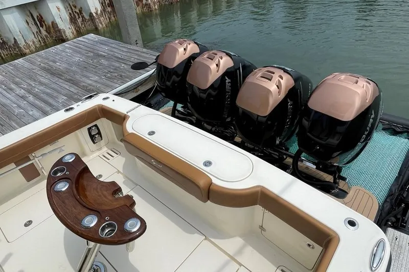Slide: The Image of 2020 Scout 420 LXF boat with four powerful outboard engines docked at a marina. - 39