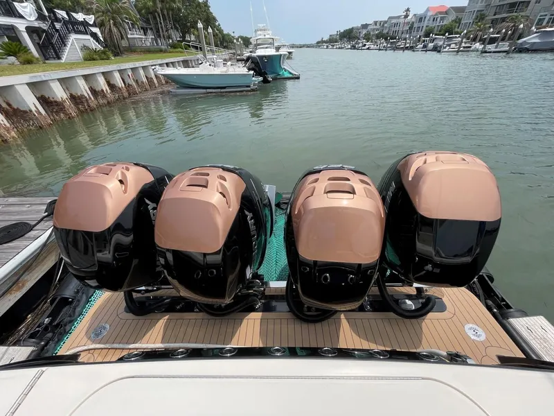 Slide: The Image of 2020 Scout 420 LXF boat with four powerful outboard engines docked in a scenic marina. - 40