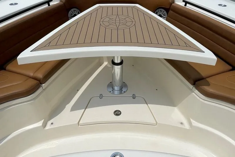 Slide: The Image of 2020 Scout 420 LXF boat interior with brown seating and a wooden table. - 5