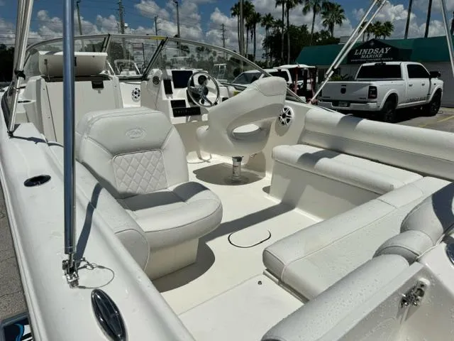 Slide: The Image of 2026 Key West 203 DFS boat interior with white seating, steering wheel, and dashboard under sunny skies. - 11
