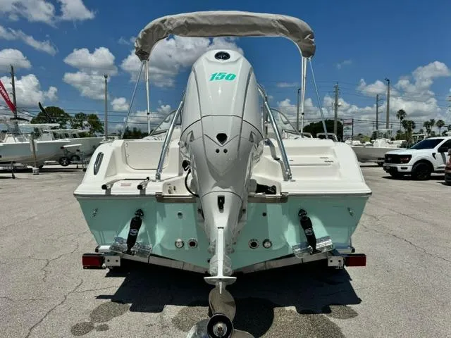 Slide: The Image of 2026 Key West 203 DFS boat with outboard motor, parked outdoors under a sunny sky. - 4