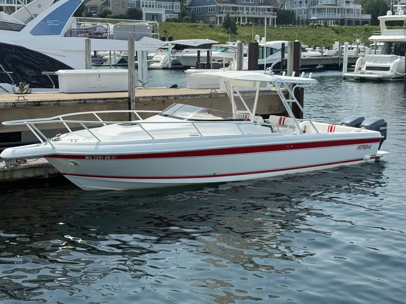The Image of 2000 Intrepid 322 boat docked in marina, featuring sleek design and red accents. - 0