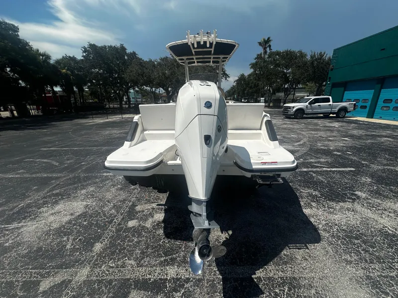 Slide: The Image of 2022 Bayliner Trophy T22CC boat with outboard motor, parked outdoors. - 3