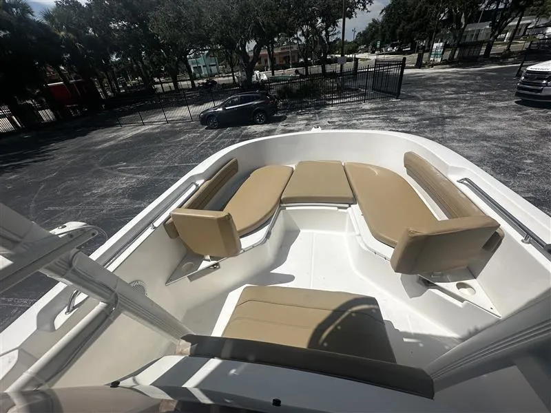Slide: The Image of 2022 Bayliner Trophy T22CC boat interior with tan seating and outboard motor. - 7