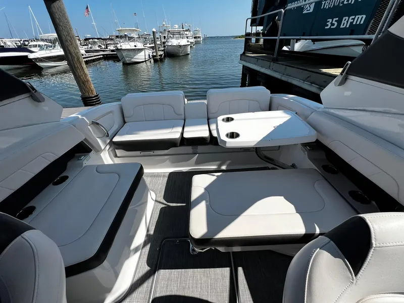 Slide: The Image of 2018 Chaparral 257 SSX boat interior with seating and table, docked at marina. - 11
