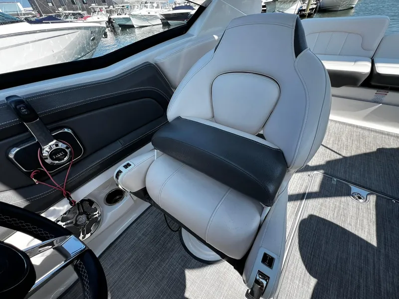 Slide: The Image of 2018 Chaparral 257 SSX boat interior with white and black seating, steering wheel, and control panel. - 13