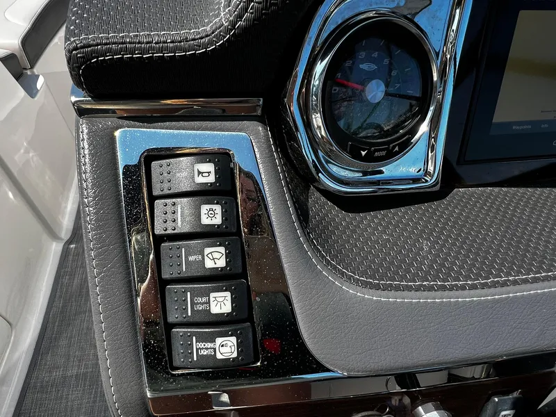 Slide: The Image of Dashboard controls of a 2018 Chaparral 257 SSX boat, featuring various switches and a gauge. - 21
