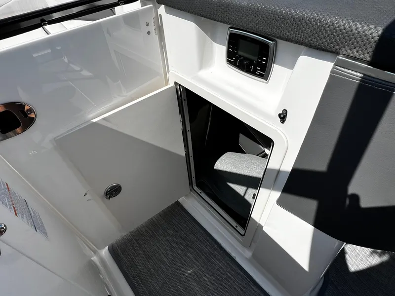 Slide: The Image of 2018 Chaparral 257 SSX boat interior storage compartment with control panel. - 22