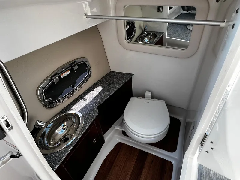 Slide: The Image of 2018 Chaparral 257 SSX boat bathroom with sink, toilet, and mirror. - 25