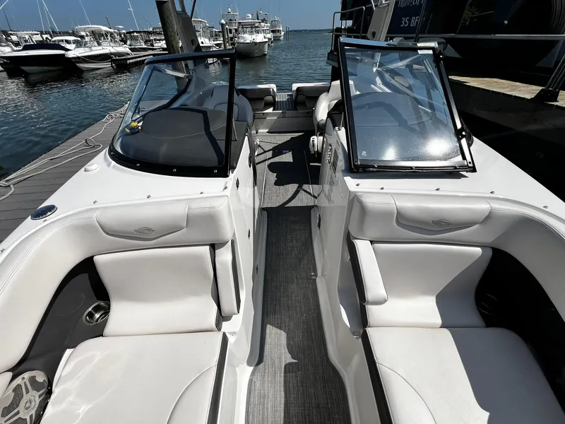 Slide: The Image of 2018 Chaparral 257 SSX boat interior with white seating at a marina. - 29