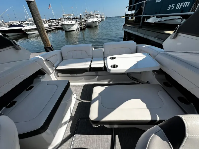 Slide: The Image of 2018 Chaparral 257 SSX boat interior with seating and table, docked at marina. - 32
