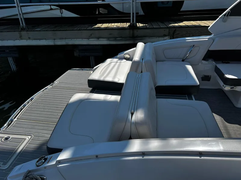 Slide: The Image of 2018 Chaparral 257 SSX boat interior with white seating and deck near dock. - 5