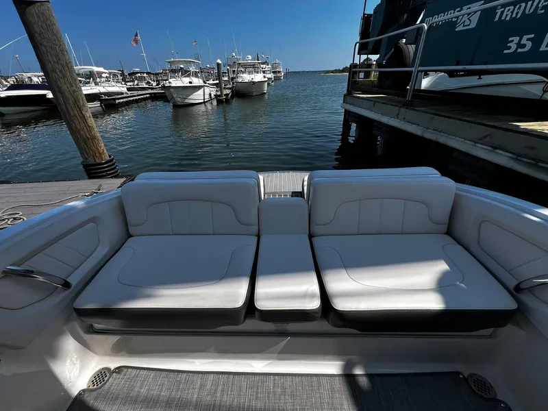 Slide: The Image of 2018 Chaparral 257 SSX boat interior with white seating at a marina. - 7