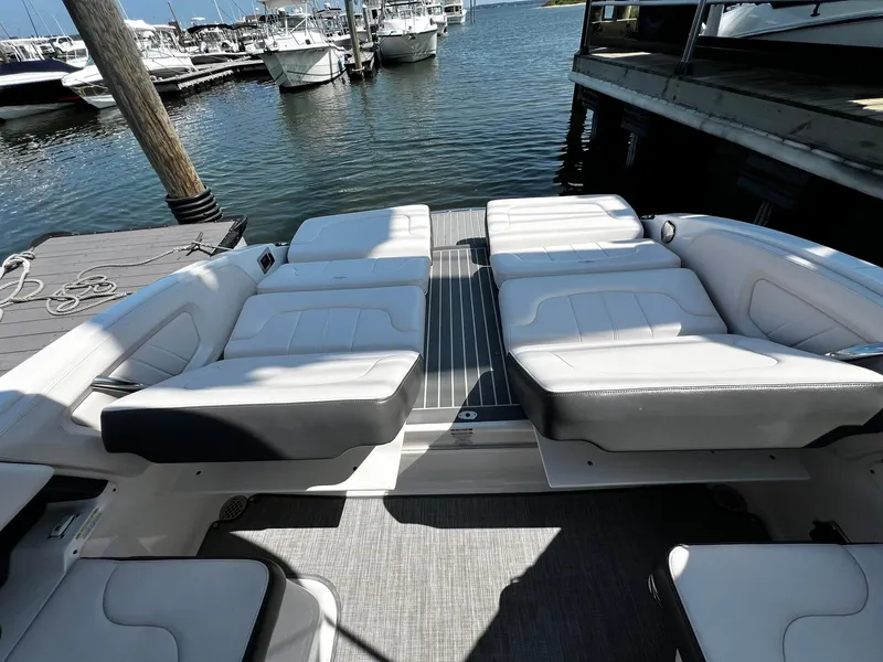 Slide: The Image of 2018 Chaparral 257 SSX boat interior with white seating at a marina. - 8