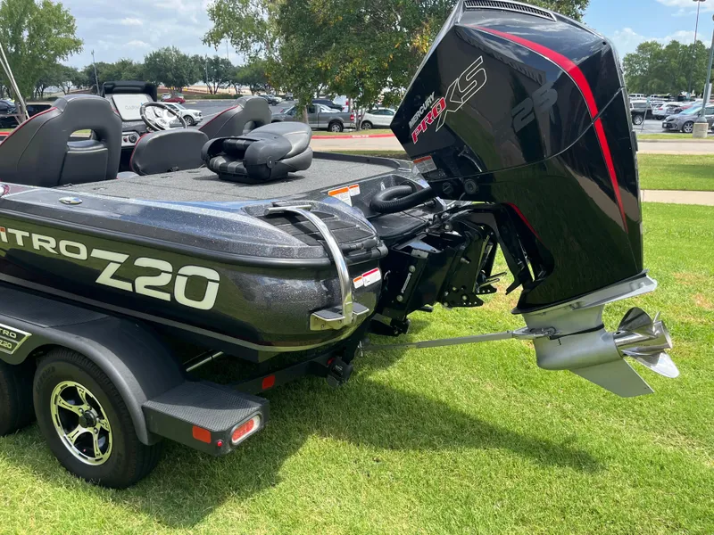 Slide: The Image of 2023 Nitro Z20 boat on trailer, parked on grass, showcasing sleek design and seating. - 11