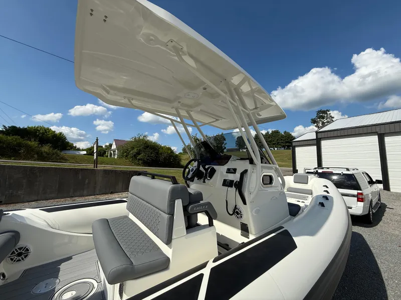 Slide: The Image of 2026 Brig Eagle 8 boat with seating and canopy, parked outdoors under a clear sky. - 13