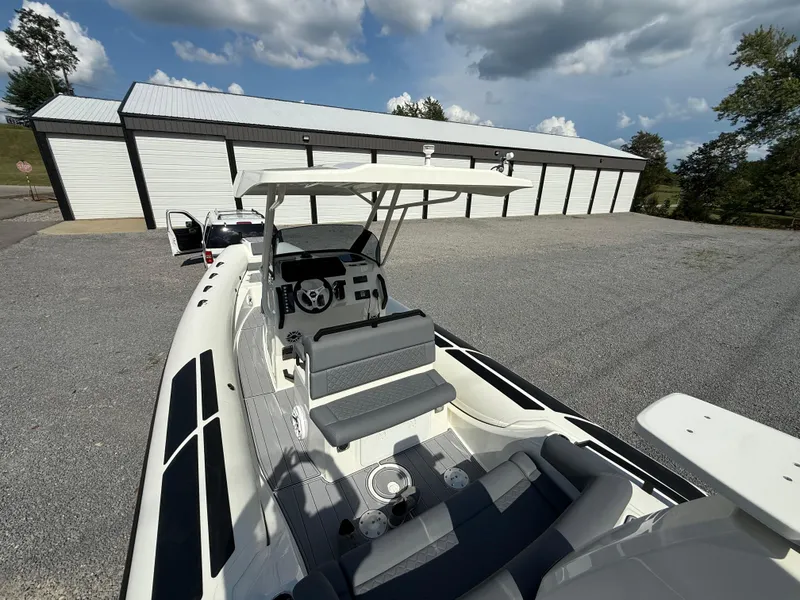 Slide: The Image of 2026 Brig Eagle 8 boat with sleek design, parked near storage facility under cloudy sky. - 17