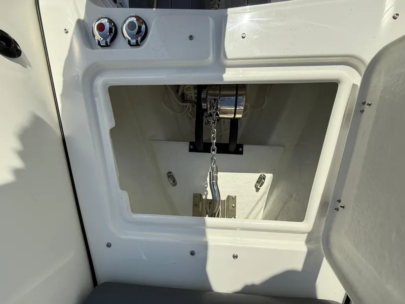 Slide: The Image of Anchor compartment of 2026 Brig Eagle 8 boat, featuring chain and controls. - 25
