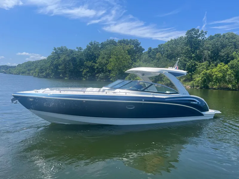 Slide: The Image of 2023 Formula 350 Crossover Bowrider I/O on a serene lake with lush greenery. - 24