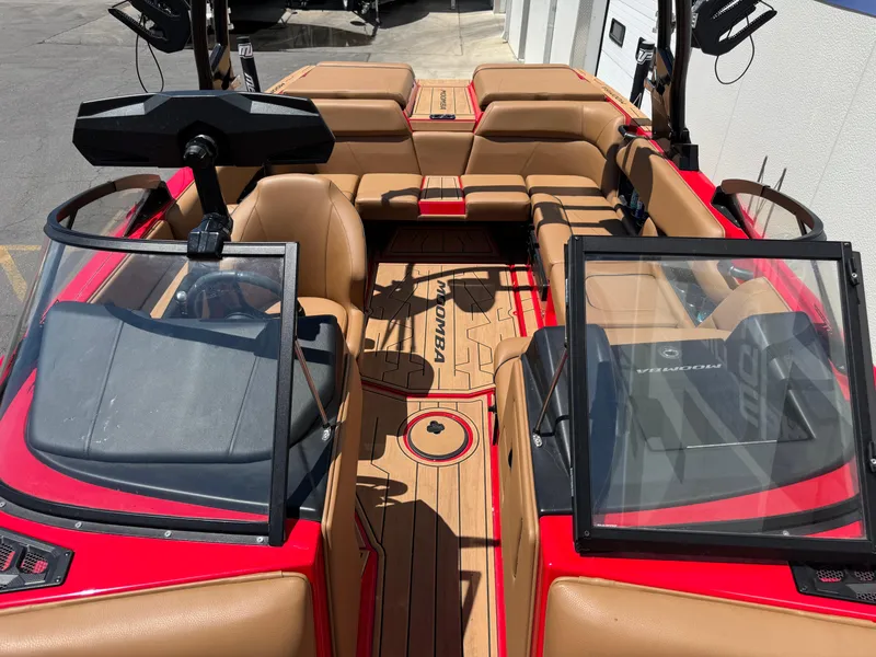 Slide: The Image of 2024 Moomba Craz boat interior with tan seating and red accents. - 9