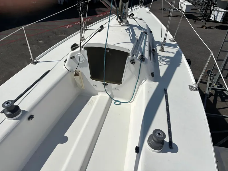 Slide: The Image of 1997 J Boats J/80 sailboat deck with winches and rigging, docked in a marina. - 6